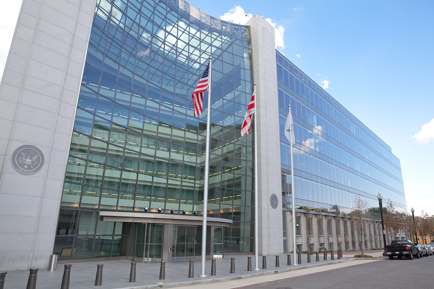 Flagpoles in front of a glass-covered building