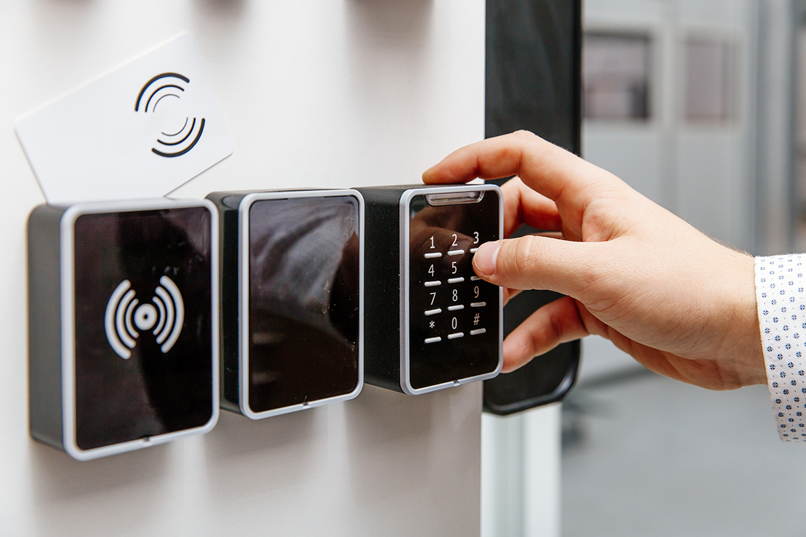A hand entering a number code on a security panel