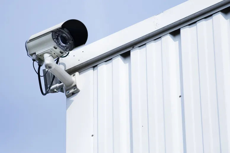 A camera mounted on the top of an exterior building wall